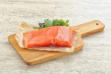 Raw salmon fillet over board