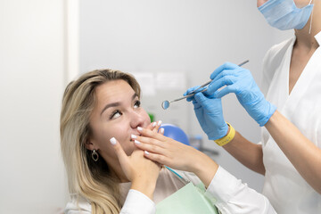 scared and frightened female patient feels dentist phobia, young girl in panic, she is afraid of...