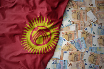 colorful waving national flag of kyrgyzstan on a euro money background. finance concept