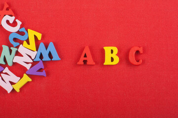 ABC word on red background composed from colorful abc alphabet block wooden letters, copy space for...