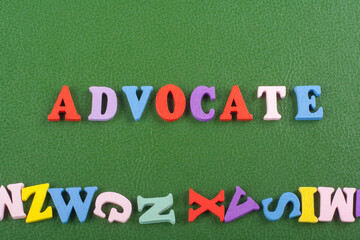 ADVOCATE word on green background composed from colorful abc alphabet block wooden letters, copy space for ad text. Learning english concept.