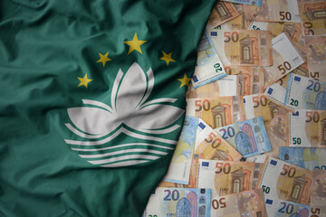 colorful waving national flag of Macau on a euro money background. finance concept