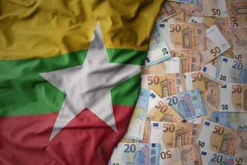 colorful waving national flag of myanmar on a euro money background. finance concept