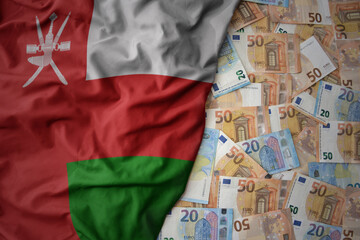 colorful waving national flag of oman on a euro money background. finance concept