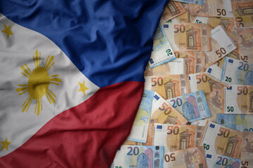 colorful waving national flag of philippines on a euro money background. finance concept