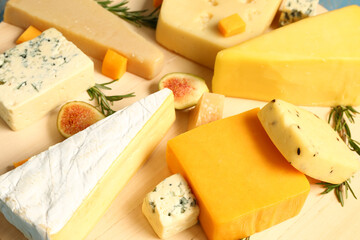 Tasty cheese on wooden board, closeup