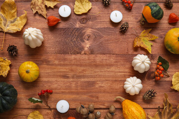 Frame made of candles and beautiful autumn decor on wooden background
