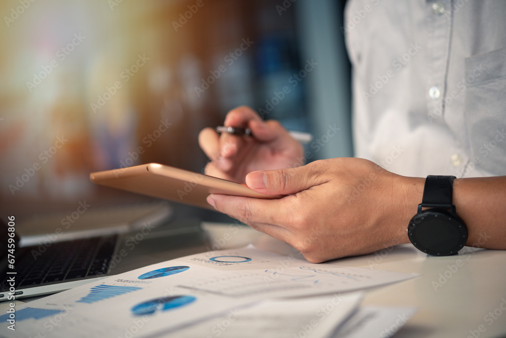 Poster businessman working with tablet presentation analyzing data planning documents graphs and chart on d