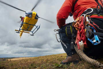 Selective focus on safety harness of paramedic of emergency service in front of landing helicopter....