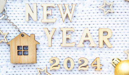 House key with keychain cottage on cozy festive knitted background with stars, bokeh. Happy New...
