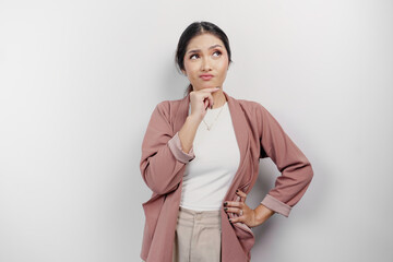 An Asian woman employee wearing a cardigan looks so confused between choices, isolated by a white...