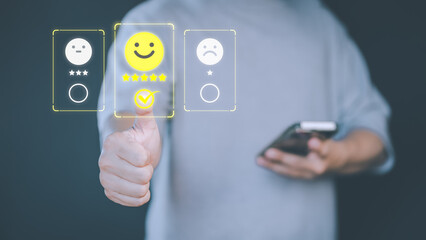 Male hand touching the virtual screen on happy smile face icon to give satisfaction in service. Online review concept of assessment testimonial customer service and feedback, Opinion rating very good.