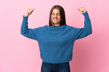 Young Uruguayan woman isolated on pink background doing strong gesture