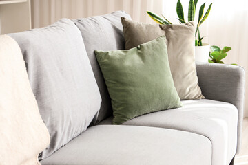 Grey sofa with cushions in living room, closeup - obrazy, fototapety, plakaty