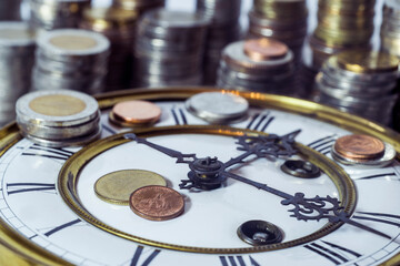 stack of coins on vintage clock