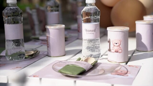 Kid's birthday party, kids birthday party theme teady bear or grizzly bear theme. Kids tiny dinner table with plates and water. Kids outdoor party with balloons and nice decorations.