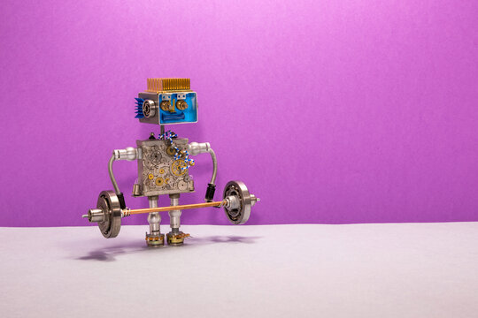 A toy robot holds a heavy metal barbell in its hands. Sports training and powerlifting concept
