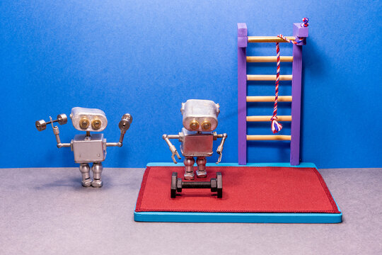 A toy gym. Robots sportsman exercises with dumbbells. Workout training and powerlifting concept