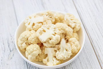 Cauliflower vegetables standing on a white wooden table