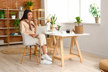 Young woman working with laptop at home office