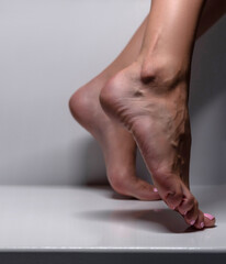 Closeup shot of healthy beautiful female feet. Visible veins. Si