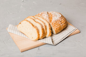 Assortment of freshly sliced baked bread with napkin on rustic table top view. Healthy unleavened...