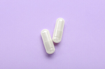 White capsules on purple background