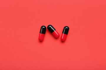 Medical capsules on red background