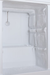 Empty white freezer with ice buildup on the walls.
