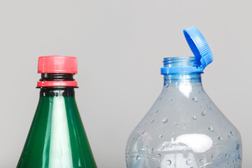 Example of older model and new cap attached to plastic bottle, connected to the neck of the bottle...