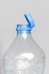 Close up of new cap attached to plastic bottle, connected to the neck of the bottle by solid tab...