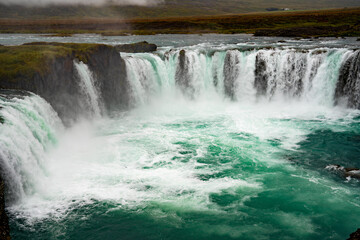 Fototapeta premium A tranquil waterfall cascading into a calm lake.