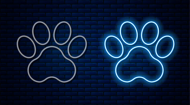Glowing neon line Paw print icon isolated on brick wall background. Dog or cat paw print. Animal track. Vector