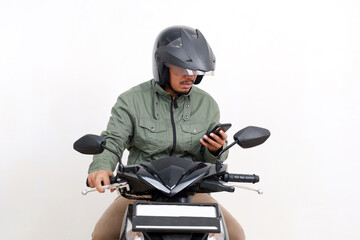 Shocked Asian man holding a cell phone while riding a motorcycle. Isolated on white background