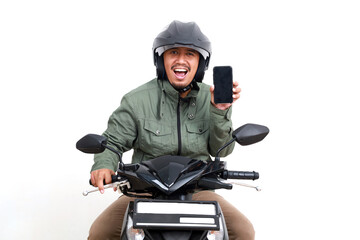 Happy Asian man showing a blank cell phone screen while riding a motorcycle. Isolated on white background