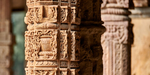 Stone columns with decorative bas relief of Qutb complex in South Delhi, India, close up pillars