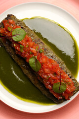 Fish stuffed grape leaves on a plate.