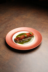 Fish stuffed grape leaves on a plate.