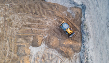The tractor digs the ground. View from a drone