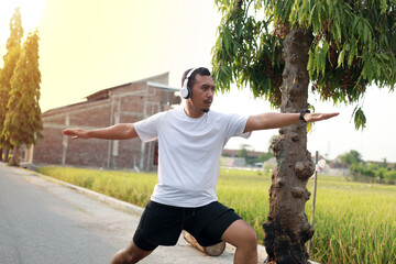 Asian adult man stretching before doing outdoor exercise. Yoga pose