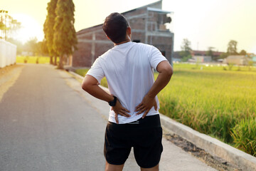 Asian Man with back pain during doing outdoor exercise
