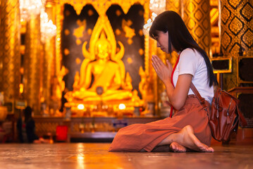 Happy Asian Woman Praying with Buddha in Temple.Concept Travel