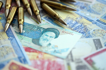 Many bullets and iranian rials money bills close up. Concept of terrorism funding or financial...