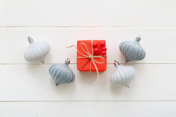 Gift box with rowan and Christmas balls on white wooden background