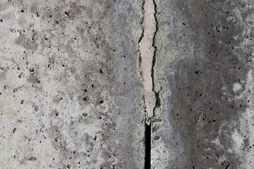 Texture of old cracked concrete wall. Rough gray concrete surface. The gap between the reinforced concrete slabs. Perfect for background and design. Close-up. High resolution.