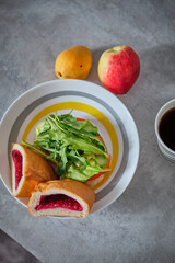 Pie with raspberries, sandwich with arugula on a plate. Nectarine and apricot on the table.