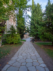 The grey rock curbstone walkway to the church with green pine.