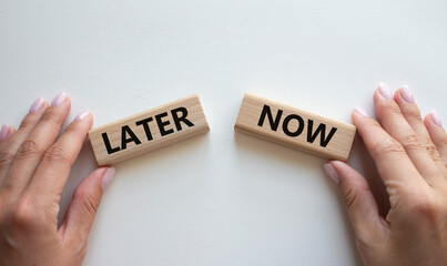 Now vs Later symbol. Concept word Now vs Later on wooden blocks. Businessman hand. Beautiful white background. Business and Now vs Later concept. Copy space