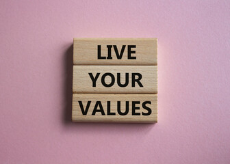 Live your values symbol. Concept words Live your values on wooden blocks. Beautiful pink background. Business and Live your values concept. Copy space.