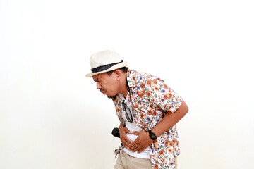 Painful asian adult man tourist standing while holding his stomach. Suffering from stomach ache....